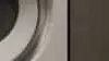 Front load ASKO washing Machine in moody laundry.