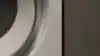 Front load ASKO washing Machine in moody laundry.