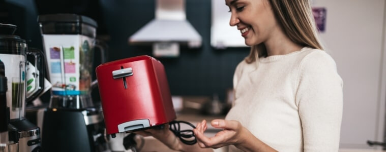 Woman happily looking at small kitchen appliances during the Black Friday Sale
