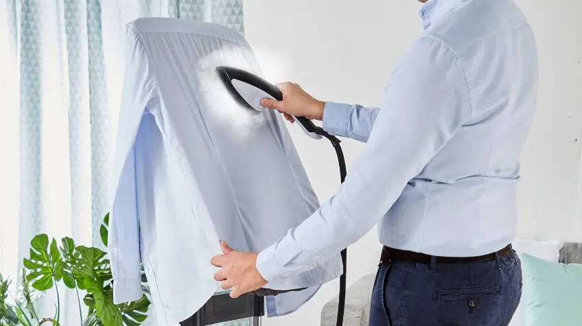 man steams shirt with Tefal garment steamer