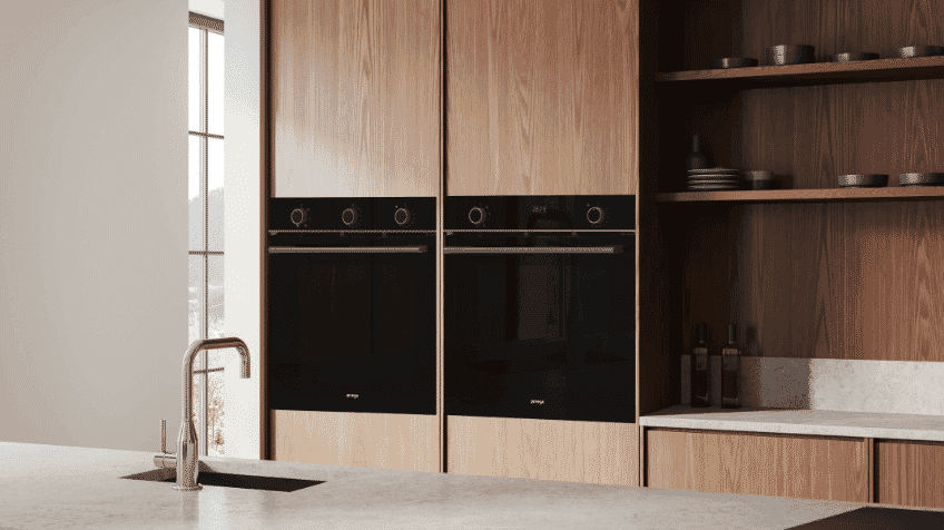 Black omega ovens side by side in dark kitchen