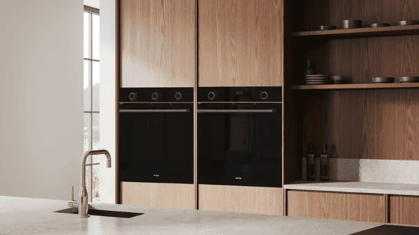 Black omega ovens side by side in dark kitchen