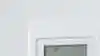 Man pointing remote to air con on the wall.