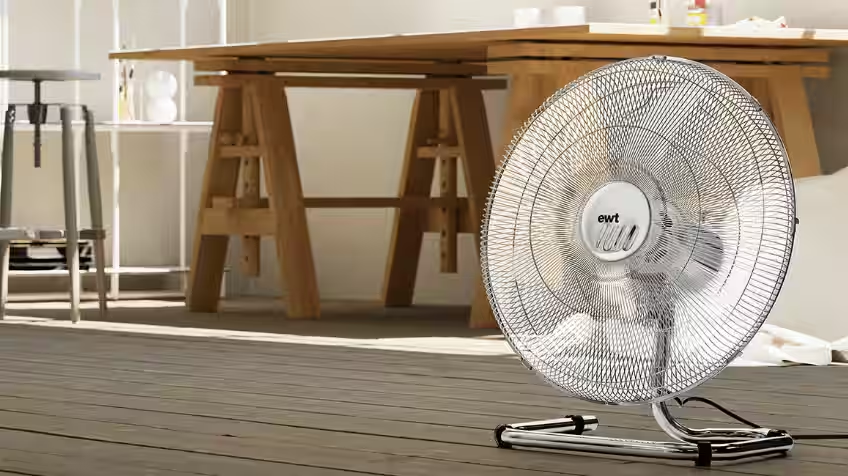 lifestyle image of an ewt portable fan on the floor of a living room.