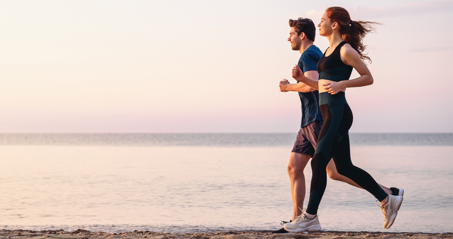 Image of man and woman running on a beach