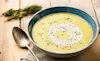 Delicious bowl of hot leek and potato soup on a wooden table