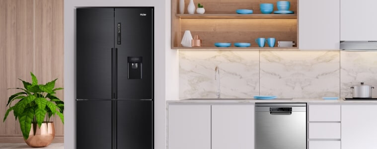 A black fridge in a white Lshaped kitchen