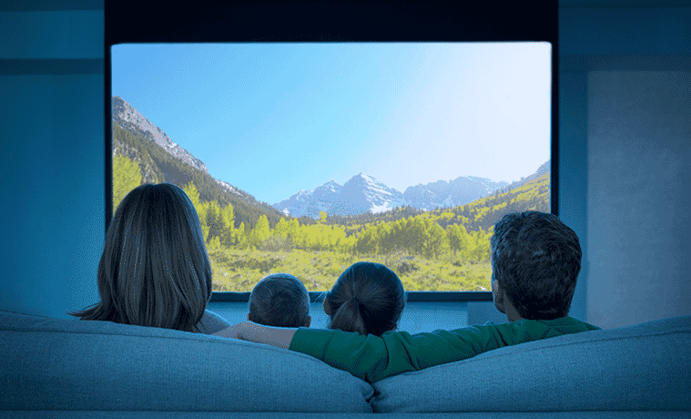 Rear view of mum dad and child watching TV at home on the couch