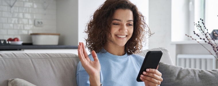 Teenage girl smiles as she uses her smartphone