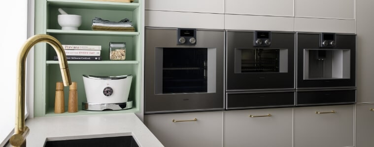 White and taupe kitchen with matte black appliances and deep storage drawers for small appliances