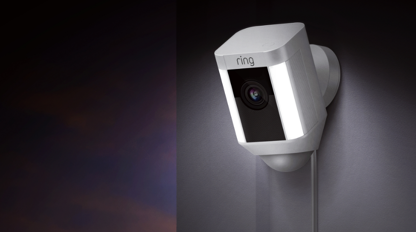 Ring Spotlight security camera sitting outside with motion lights on