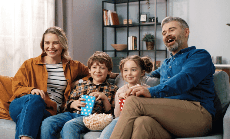 a mother father son and daughter watching an Easter movie at home 