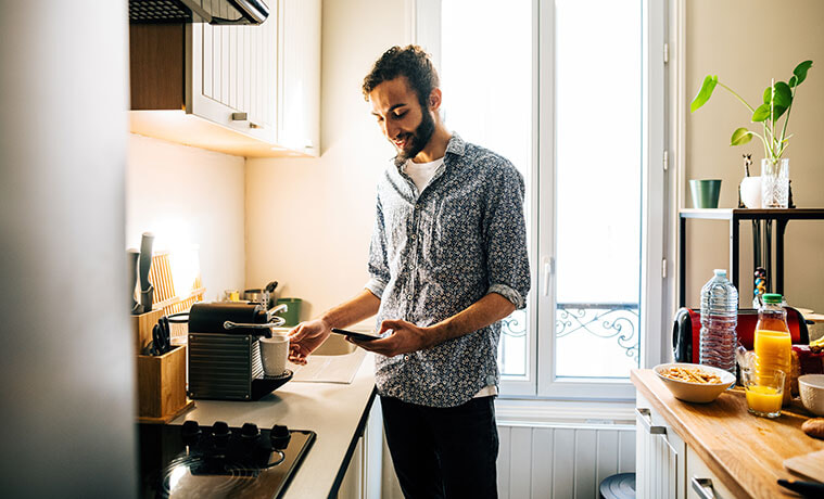 Man prepares coffee at home using a capsule coffee machine