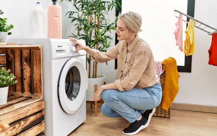 A woman does the washing with her young daughter