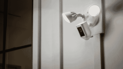 Ring floodlight camera outside home with two lights on
