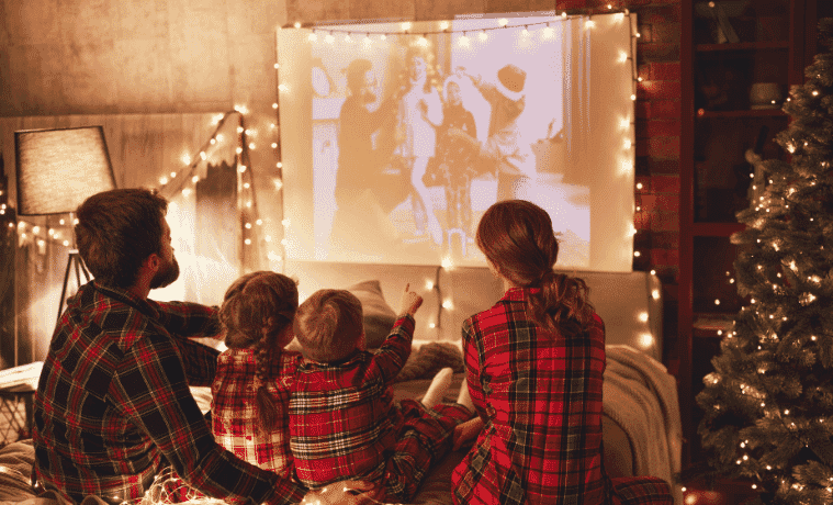 A young family watch a movie together on a projector