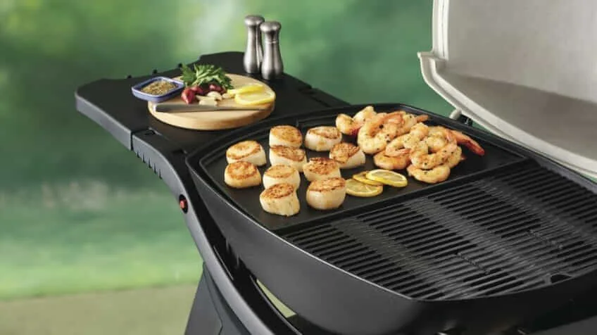 A Weber hotplate is used to cook prawns and fish cakes on a Weber BBQ