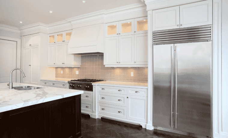 A classically styled white kitchen with silver appliances