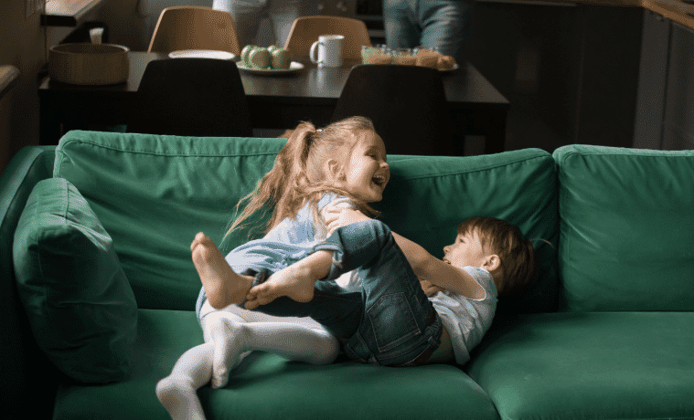 Happy children playing on their couch 