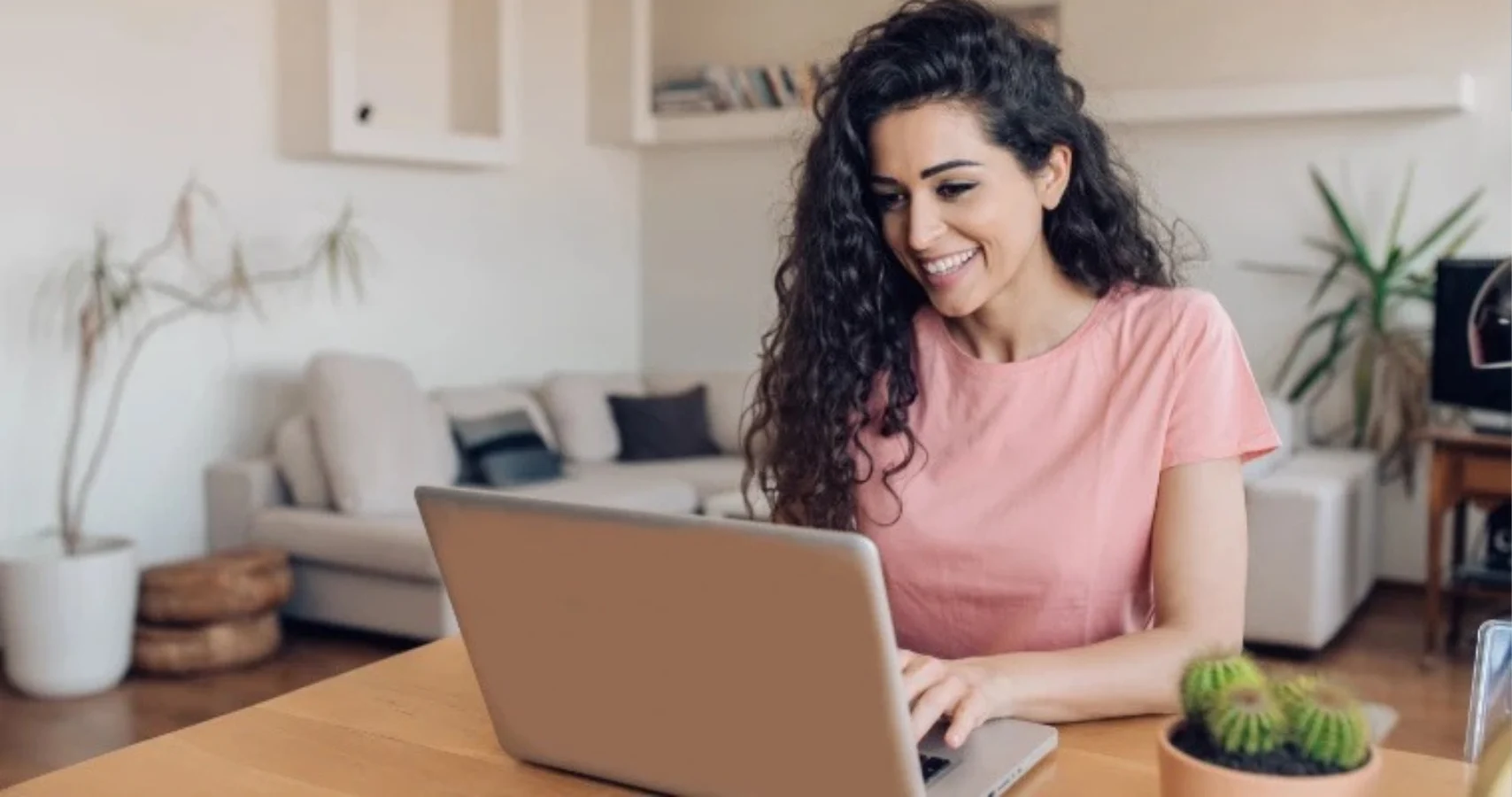 Woman on a laptop in her living room smiling.