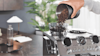 Man pouring beans into his manual De'Longhi machine.