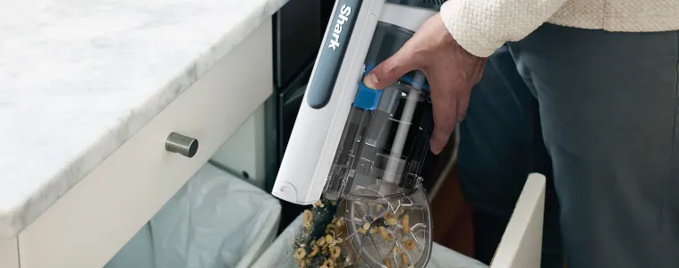 Man emptying his Shark PowerPro into the bin.