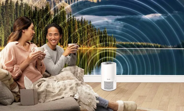 Image of two people smiling and holding mugs with the Breville Air Purifier on the floor in a forest background.