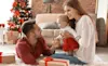 Young parents in the living room with their baby and Christmas gift