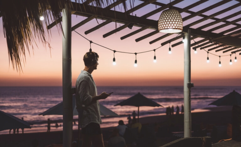 A man watches the sunset at a tropical beach