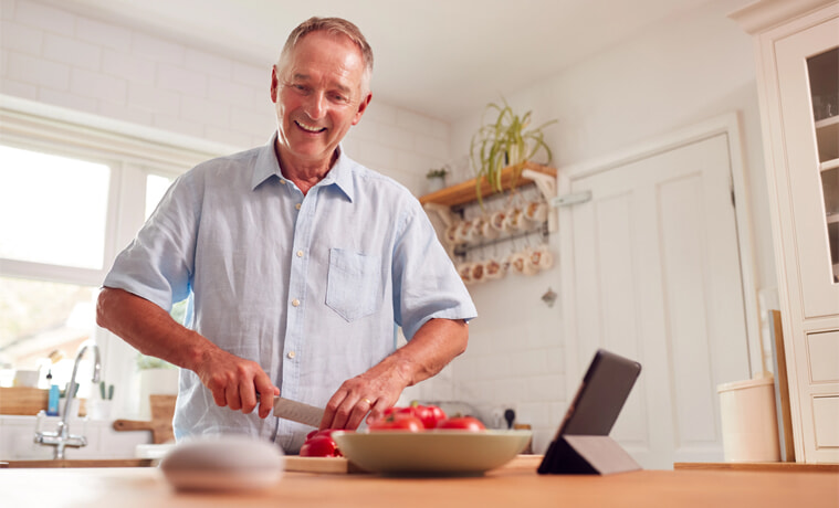A man uses his Google Nest Mini while cooking