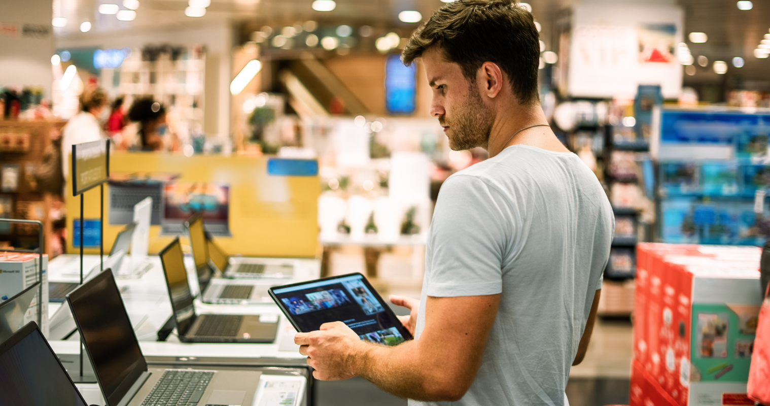 Image of a man shopping for a tablet in a store