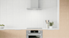Black Hair rangehood and oven in a salmon kitchen