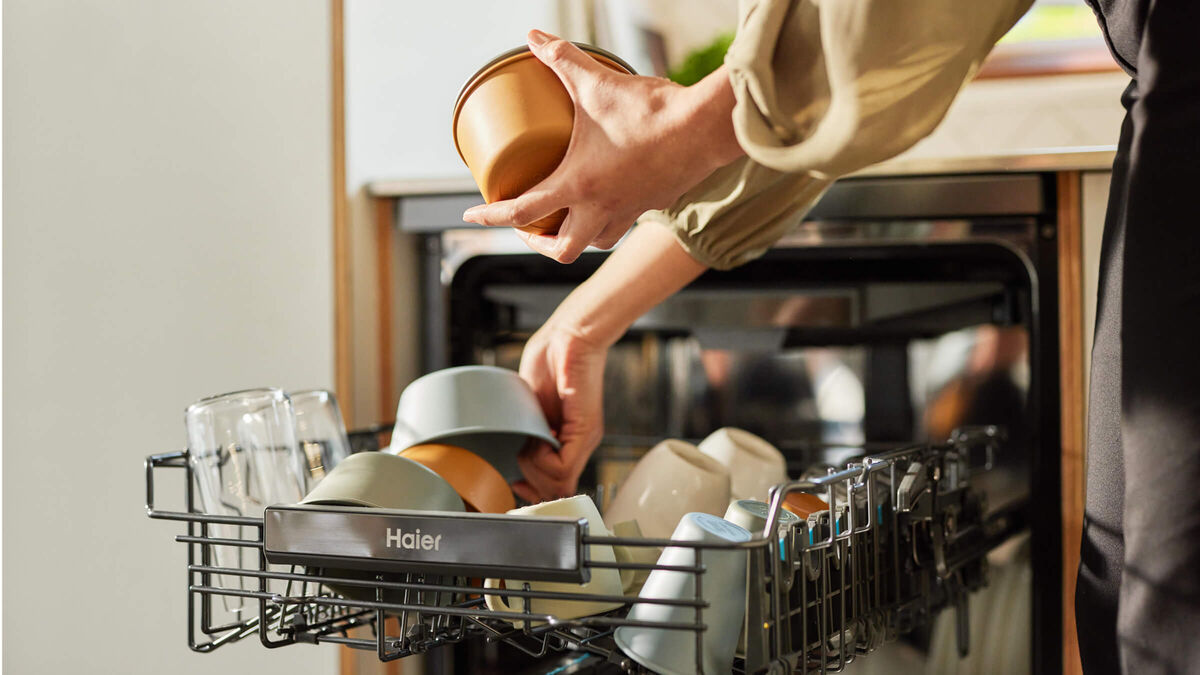 Woman stacking Haier dishwasher in her kitchen 