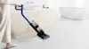 Woman manoeuvring Dyson G1 in bathroom.