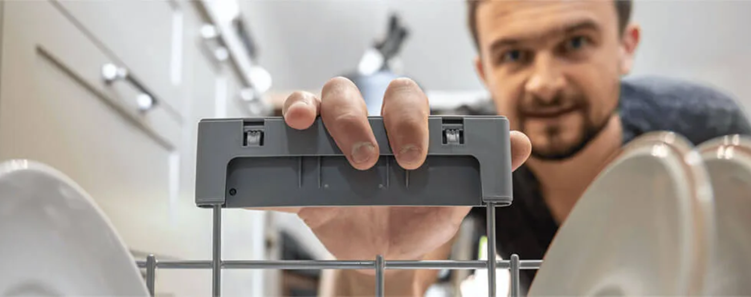 Image of a man looking inside a Dishwasher
