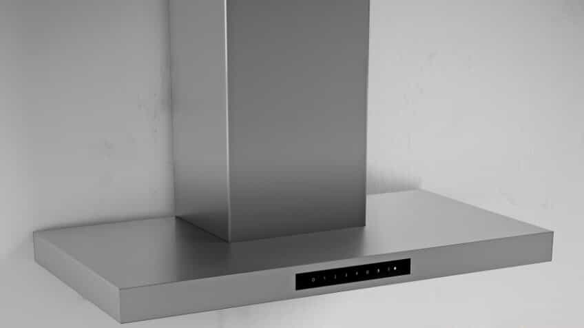A silver Smeg rangehood against a white wall