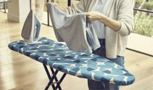 A woman ironing on the Joseph Joseph ironing board