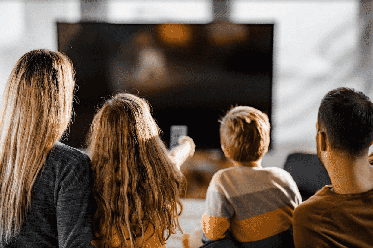 Rear view of a relaxed family watching a movie in the living room