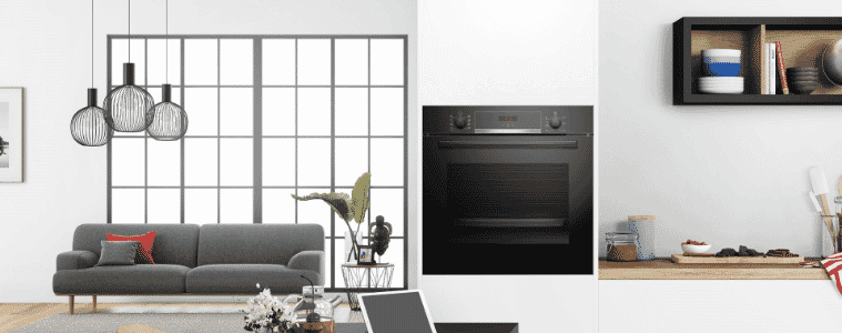 A black wall oven in a white kitchen