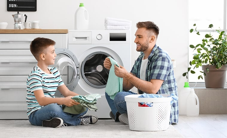 A son helps his father unload and fold the laundry