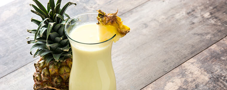 Virgin pina colada cocktail next to a pineapple