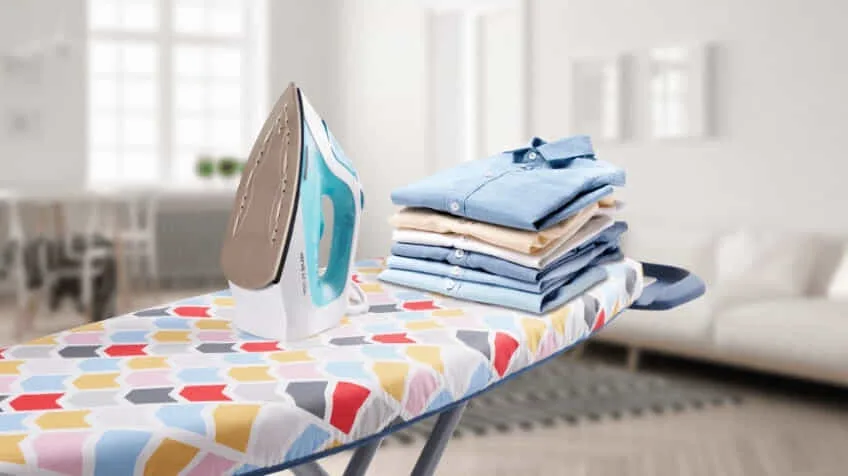 Sunbeam food processor with cream in it placed next to a delicious cake with strawberries on top