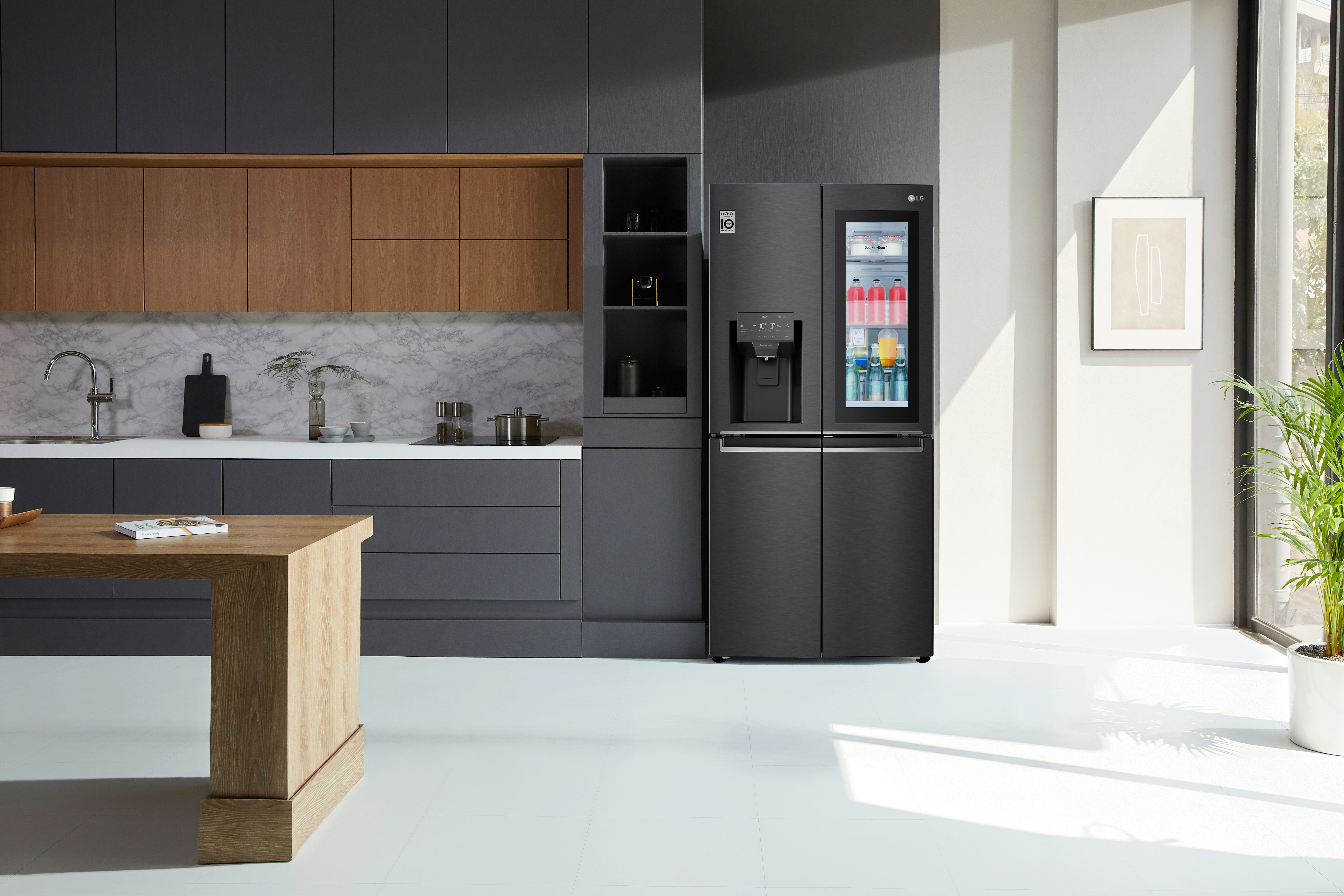 A black LG InstaView Fridge in a matching black kitchen with warm timber accents