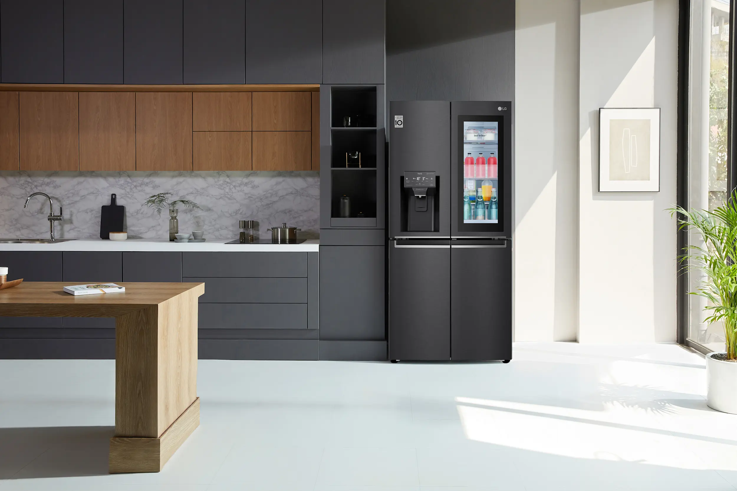 A black LG InstaView Fridge in a matching black kitchen with warm timber accents