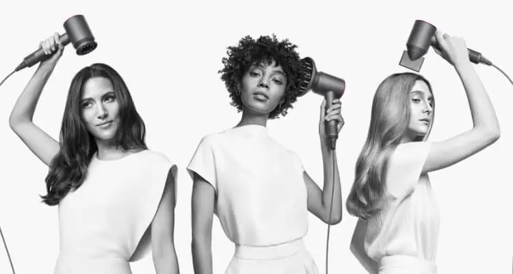 3 women using Dyson hair dryer with different attachments.