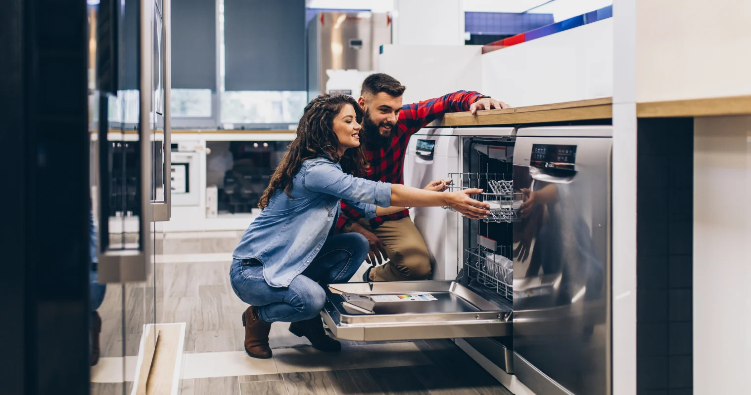 Image of man and woman in appliance store looking at the inside of a Dishwasher