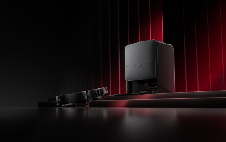 Robot vacuum and its auto-empty dock on a dark studio set with red lighting