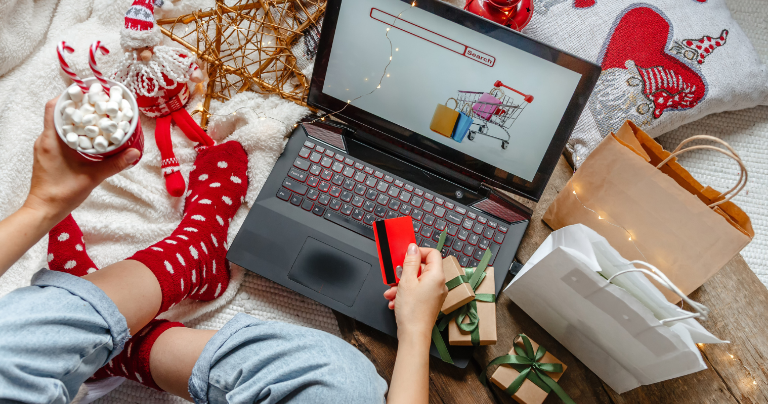 Image of someone online shopping with Christmas decorations around them