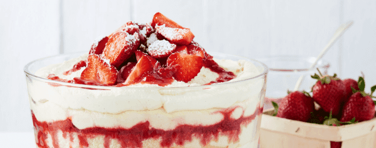 Strawberry Tiramasu on a table next to a fresh bowl of strawberries