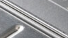 A close up of an open grease tray on a Weber BBQ
